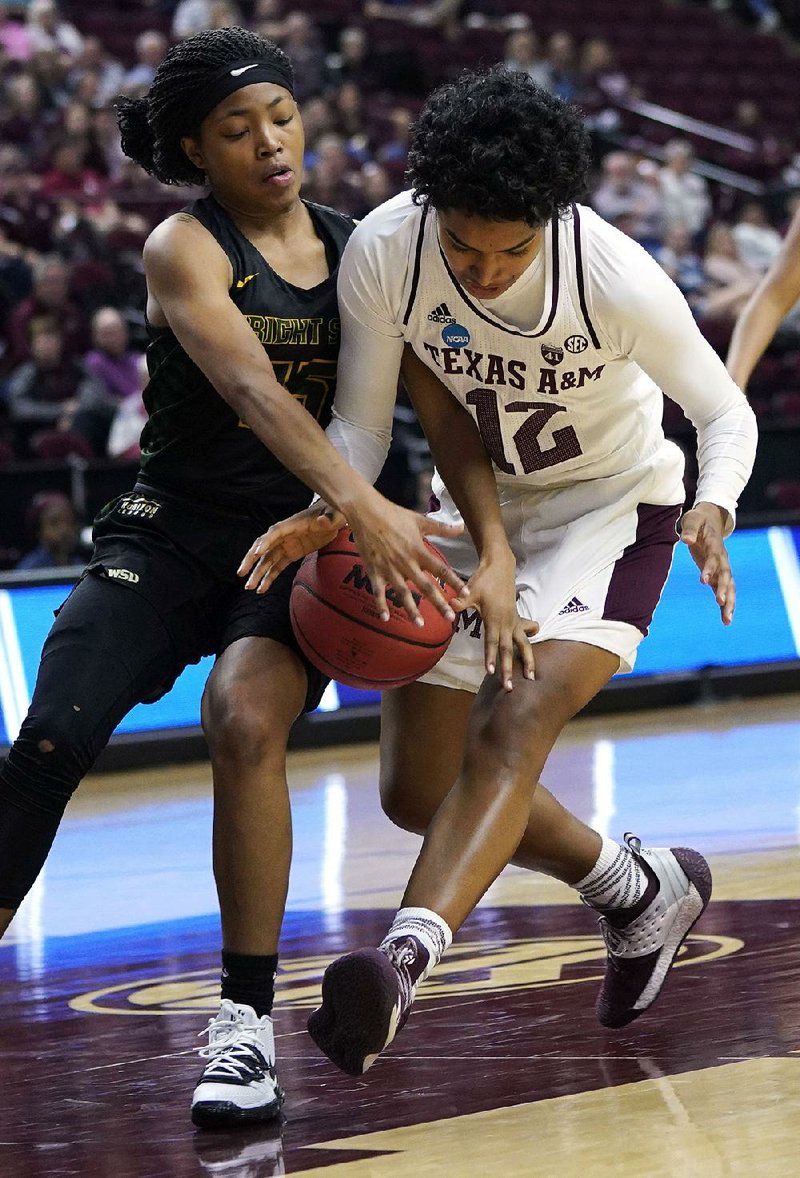 Wright State’s Angel Baker (left) forces a jump ball with Texas A&M’s Cheah Rael-Whitsitt (12) during the first half of the Aggies’ 84-61 victory on Friday.