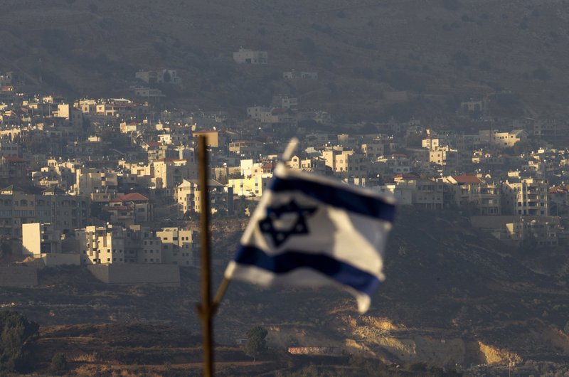 FILE - In this file photo dated Thursday, Oct. 11, 2018, an Israeli flag in front of the village of Majdal Shams in the Israeli-controlled Golan Heights. Syria slammed President Donald Trump's abrupt declaration that Washington will recognise Israel's sovereignty over the Israeli-occupied Golan Heights, saying Friday March 22, 2019, the statement was &quot;irresponsible&quot; and a threat to international peace and stability. (AP Photo/Ariel Schalit, FILE)