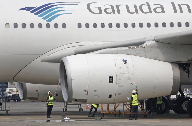 FILE - In this Sept. 28, 2015, file photo, workers clean a jetliner at GMF AeroAsia facility at Soekarno-Hatta International Airport in Jakarta, Indonesia. Indonesia's flag carrier is seeking the cancellation of a multibillion-dollar order for 49 Boeing 737 Max 8 jets, citing a loss of confidence in the model following two crashes in the space of a few months. (AP Photo/Dita Alangkara, File)