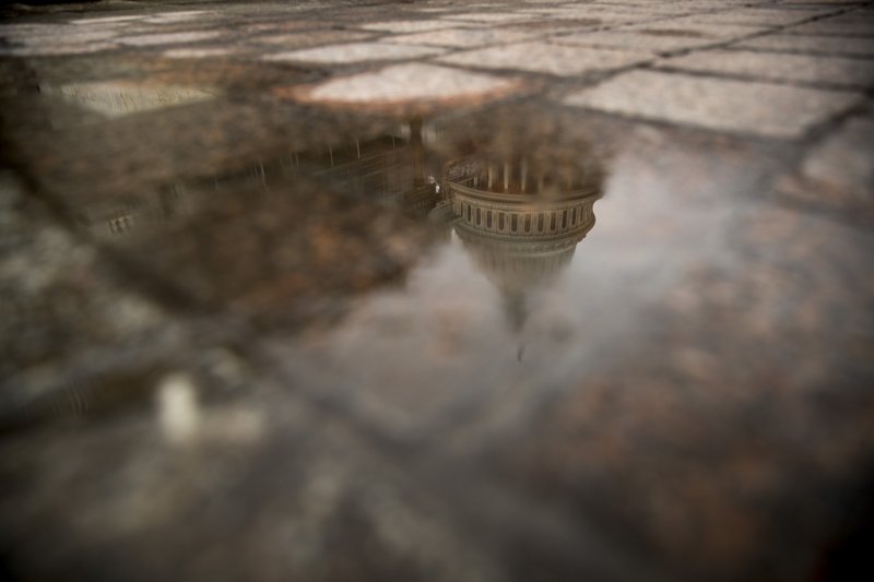 FILE- In this Feb. 22, 2019, file photo the dome of the U.S. Capitol Building is visible in reflection in Washington. On Friday, March 22, the Treasury Department releases federal budget data for February. (AP Photo/Andrew Harnik, File)