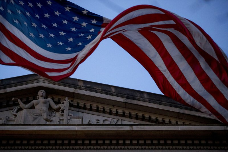 An American flag flies outside the Department of Justice in Washington, Friday, March 22, 2019. Special counsel Robert Mueller has concluded his investigation into Russian election interference and possible coordination with associates of President Donald Trump. The Justice Department says Mueller delivered his final report to Attorney Barr, who is reviewing it. (AP Photo/Andrew Harnik)