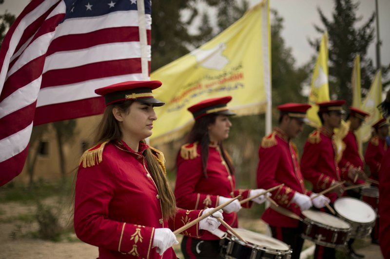 A military band performs ahead of a ceremony Saturday, March 23, 2019, at al-Omar Oil Field marking the U.S.-backed Syrian Democratic Forces capture of Baghouz, Syria, after months of fighting to oust Islamic State militants. (AP Photo/Maya Alleruzzo)