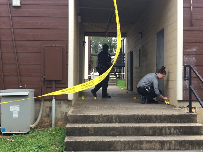 Little Rock police officials place evidence markers at the scene of a fatal shooting Saturday.