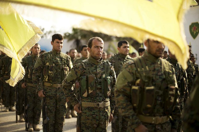 Members of the U.S.-backed Syrian Democratic Forces stand in  formation Saturday at  the al-Omar Oil Field base during a ceremony to mark the defeat of Islamic State militants in Baghouz. 