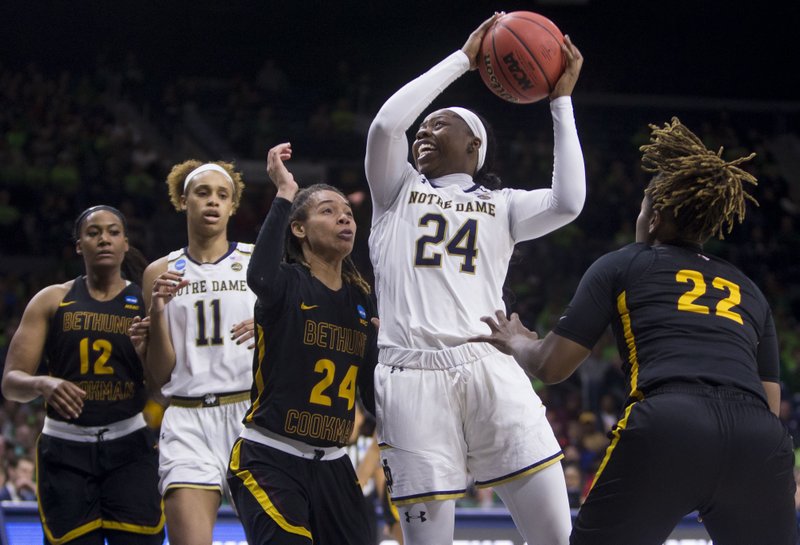 The Associated Press GO FOR IT: Notre Dame's Arike Ogunbowale (24) goes up for a shot between Bethune-Cookman's Angel Golden (24) and Tania White (22) during a first-round game in the NCAA women's college basketball tournament in South Bend, Ind., Saturday.