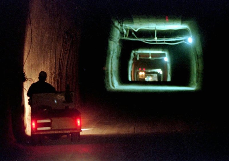 FILE - In this April 8, 1998, file photo, a worker drives a cart through a tunnel inside the Waste Isolation Pilot Plant No. 2, 150 feet below the surface near Carlsbad, N.M.  Twenty years and more than 12,330 shipments later, tons of Cold War-era radioactive waste from decades of bomb-making and research have been stashed in the salt caverns that make up the underground facility and not without issues. (AP Photo/Eric Draper, File)