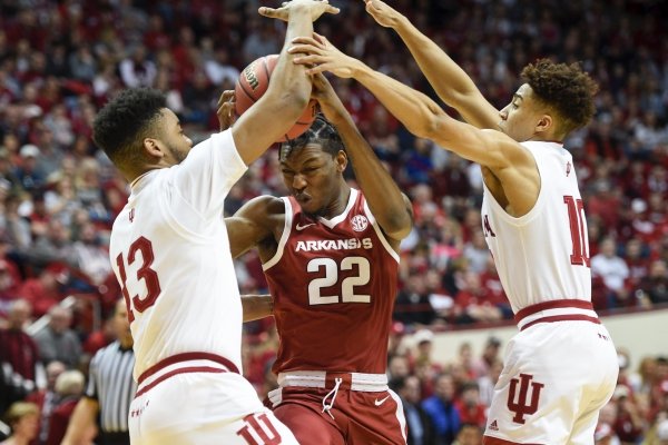 Arkansas Razorbacks forward Gabe Osabuohien (22) defends the ball from Indiana Hoosiers forward Juwan Morgan (13) and guard Rob Phinisee (10) during the first half of the NCAA National Invitation Tournament, Saturday, March 23, 2019 at the Simon Skjodt Assembly Hall at the University of Indiana in Bloomington, Ind. The Arkansas Razorbacks fell to the Indiana Hoosiers 63-60.