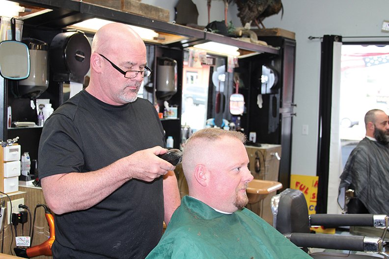 Shane Forga cuts longtime customer Steve Burroughs hair at Central City Barbershop weeks before the shop will move to a new location.