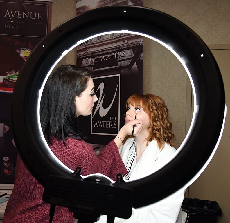 The Sentinel-Record/Grace Brown - Makeup artist Ashlyn Barker, left, with Blushed Beauty Boutique applies makeup to model Savvy Morgan during the Hot Springs Bridal Expo at the Arlington Resort Hotel &amp; Spa on Sunday, March 24, 2019.