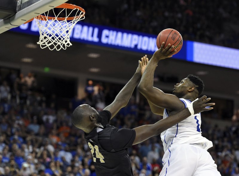 The Associated Press OVERSHOT: Duke's Zion Williamson, right, shoots over Central Florida's Tacko Fall during the second half of a second-round men's college basketball game in the NCAA Tournament in Columbia, S.C., Sunday.