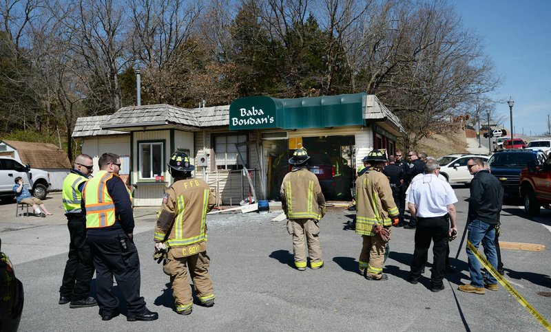 NWA Democrat-Gazette/ANDY SHUPE
Emergency personnel work Friday, March 22, 2019, to stabilize the structure of the Baba Boudan's building at 701 N. College Ave. in Fayetteville after a car struck the building.