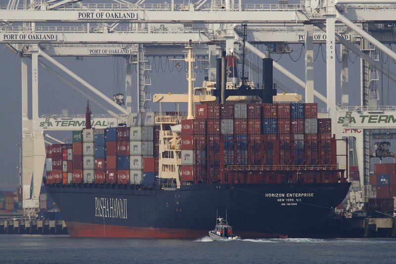 FILE - In this Nov. 14, 2018, file photo, a U.S. Coast Guard vessel patrols the Oakland estuary as the container ship Horizon Enterprise is unloaded in Oakland, Calif. The nation's business economists foresee a sharp slowdown in U.S. economic growth over the next two years, in sharp contrast to the Trump administration&#x2019;s predictions that growth will accelerate this year and next. (AP Photo/Ben Margot, File)