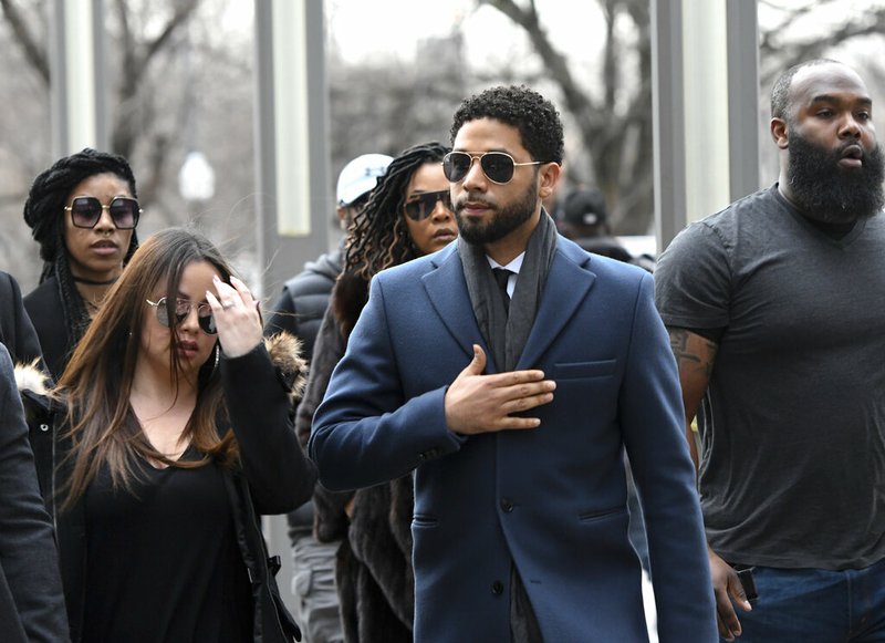Empire actor Jussie Smollett, center, arrives at the Leighton Criminal Court Building for his hearing on Thursday, March 14, 2019, in Chicago. Smollett is accused of lying to police about being the victim of a racist and homophobic attack by two men on Jan. 29 in downtown Chicago. (AP Photo/Matt Marton)