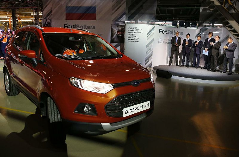 Russian Prime Minister Dmitry Medvedev (second from right) attends the start of Ford EcoSport production in 2014 at the Ford Sollers factory in Naberezhnye Chelny, Russia. That plant is one of three Russian plants that Ford says it will close. 