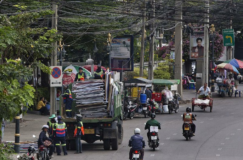 Workers load campaign billboards onto a  truck Wednesday  in Bangkok after Sunday’s election. 