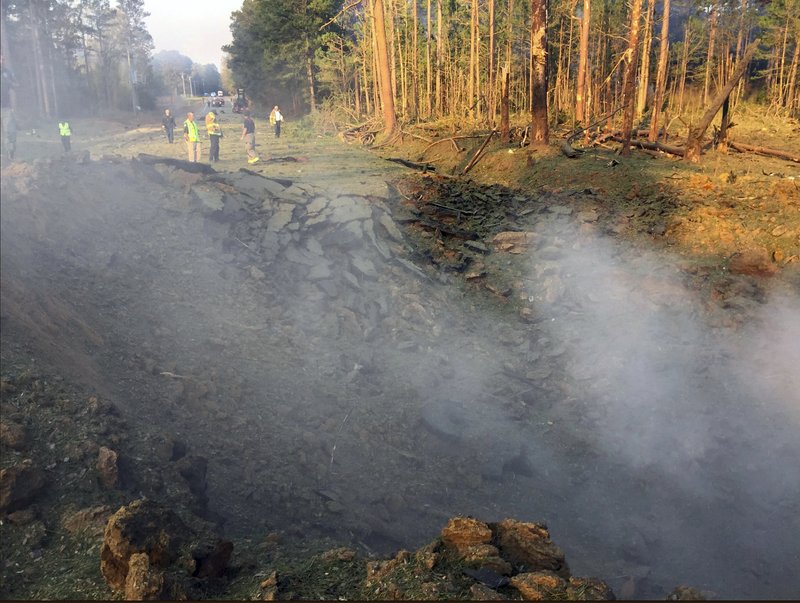 This March 27, 2019 photo provided by Arkansas Department of Transportation shows a massive crater after a commercial truck hauling ammonium nitrate exploded Wednesday, March 27, on a highway in Camden, Ark., killing the driver. According to Arkansas State Police, the driver had called 911 early Wednesday to report that his brakes had caught fire, and he was killed when the truck later exploded. (ARDOT via AP)