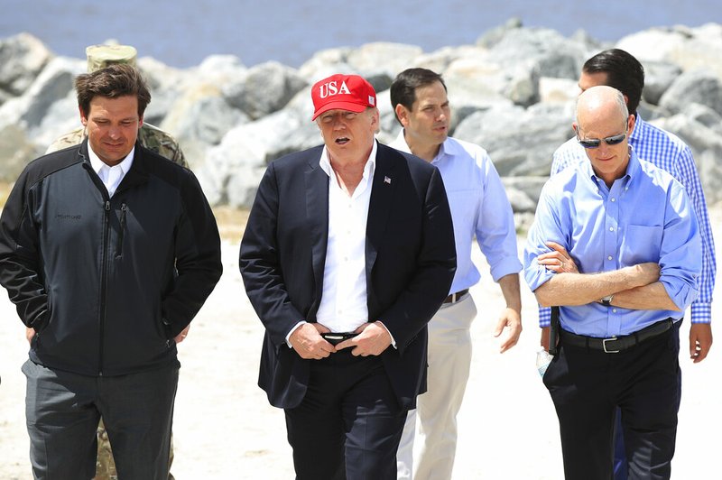 President Donald Trump walks with, from left, Florida Gov. Ron DeSantis, Sen. Marco Rubio, R-Fla., and Sen. Rick Scott, R-Fla., during a visit to Lake Okeechobee and Herbert Hoover Dike at Canal Point, Fla., Friday, March 29, 2019. (AP Photo/Manuel Balce Ceneta)