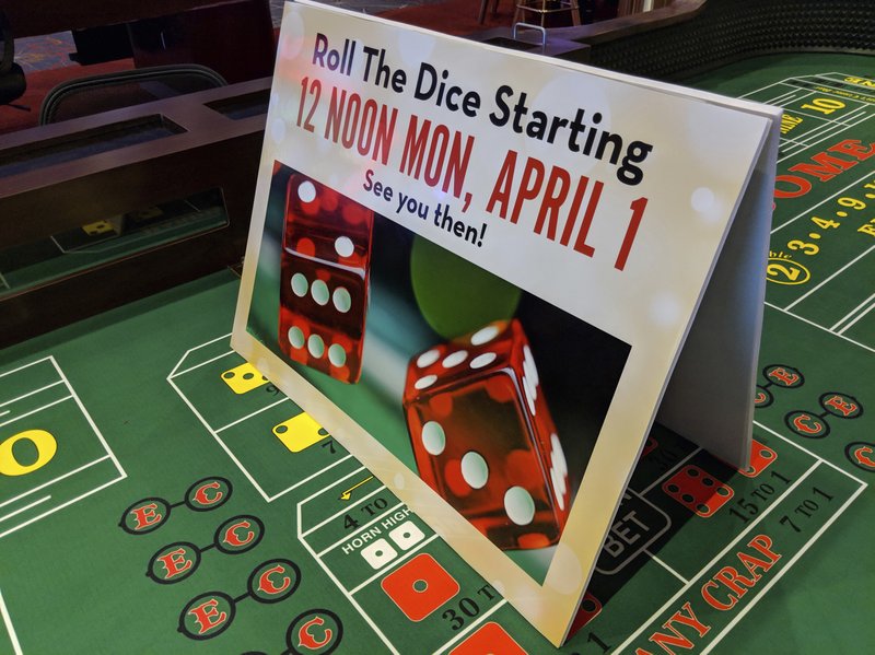 This Thursday, March 28, 2019 photo, shows a sign at a craps table at Oaklawn Racing Casino Resort advertises imminent full casino operations at the horse racing track in Hot Springs, Ark. Oaklawn and Southland Casino and Racing in West Memphis will both begin live table games on April 1, fewer than five months after voters approved a casino amendment to the state's constitution. (AP Photo/Hannah Grabenstein)