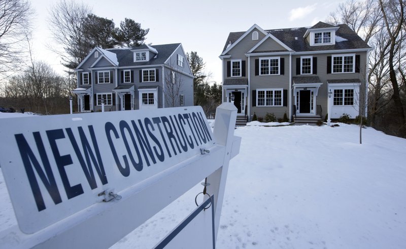 FILE- In this Feb. 21, 2019, file photo a newly constructed homes sit near a sign in Natick, Mass. On Friday, March 29, the Commerce Department reports on sales of new homes in February. (AP Photo/Steven Senne, File)