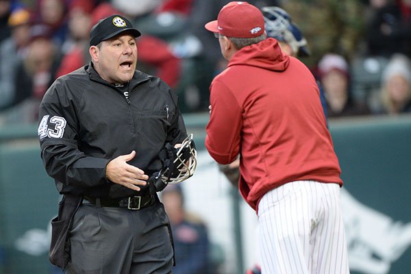 Arkansas coach Dave Van Horn (right) argues Saturday, March 30, 2019, with umpire Eddie Newsom after Newsom called third baseman Jacob Nesbit out on strikes after Nesbit was ruled to have leaned into a pitch that hit him during the ninth inning against Ole Miss at Baum-Walker Stadium in Fayetteville.