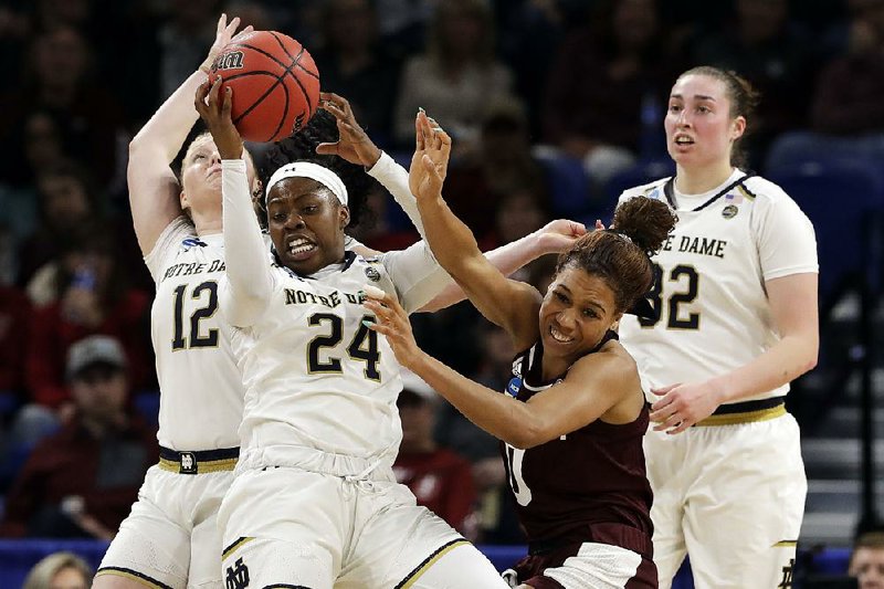 Notre Dame’s Arike Ogunbowale (24) grabs a rebound against Texas A&M’s Aja Ellison during the second half of Sunday’s Chicago Regional semifinal. Ogunbowale scored a career-high 34 points as the Irish won 87-80.
