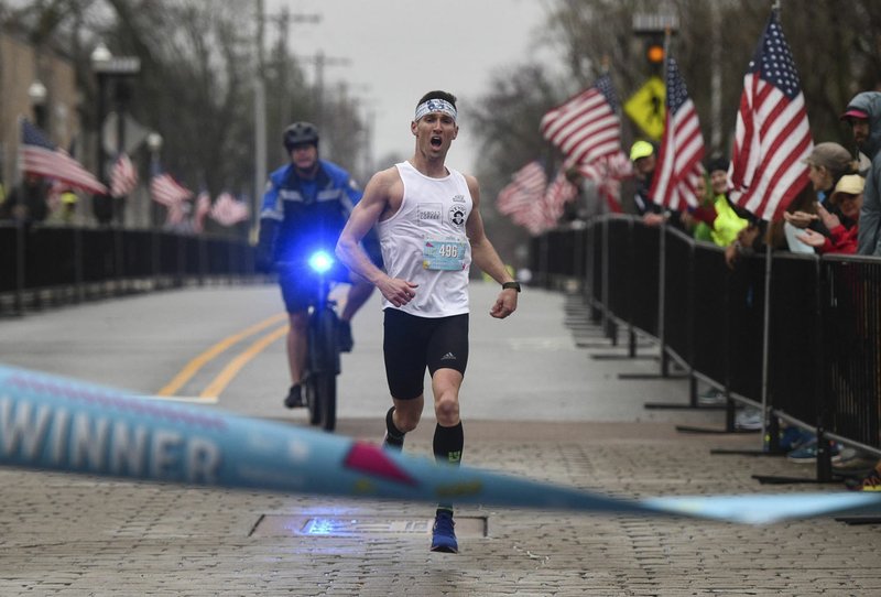 NWA Democrat-Gazette/CHARLIE KAIJO Derek Yorek of Bentonville finishes first for the men's 9th annual Run Bentonville half marathon, Saturday, March 29, 2019 at the Bentonville square in Bentonville.