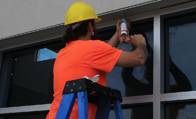 A construction worker puts the finishing touches on windows installed in the front of the aquatic center in Pine Bluff. Once finished, the center will have an eight-lane short course competition pool, and leisure and exercise pool areas among other amenities.