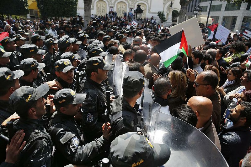 Tunisian protesters confront riot police Sunday who are trying to keep demonstrators from reaching the conference palace where Arab leaders are meeting in Tunis, Tunisia. 