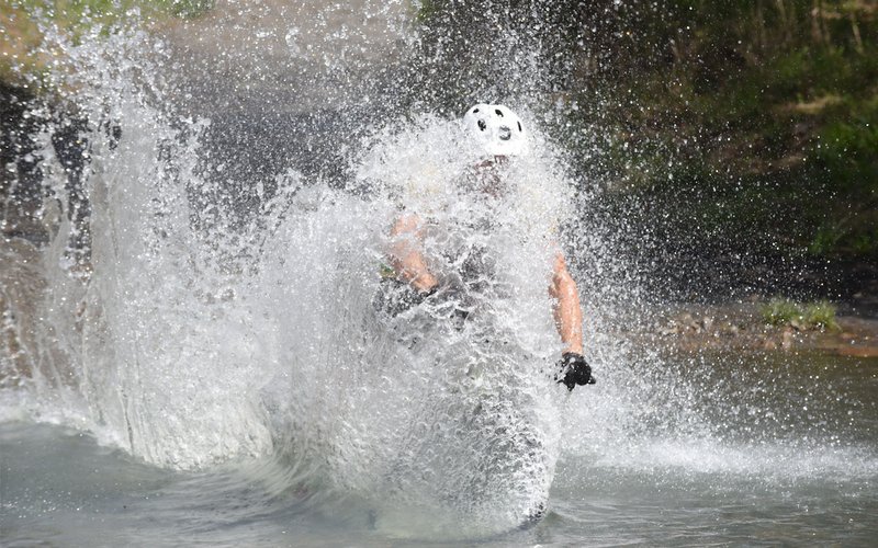 A cyclist splashes into Lee Creek during the 2017 Ozark Mountain Bike Festival. (Democrat-Gazette file photo/FLIP PUTTHOFF)