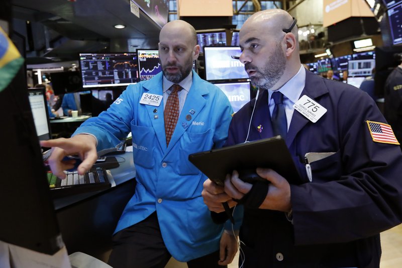 FILE- In this March 18, 2019, file photo specialist Meric Greenbaum, left, and trader Fred DeMarco work on the floor of the New York Stock Exchange. The U.S. stock market opens at 9:30 a.m. EDT on Monday, April 1. (AP Photo/Richard Drew, File)