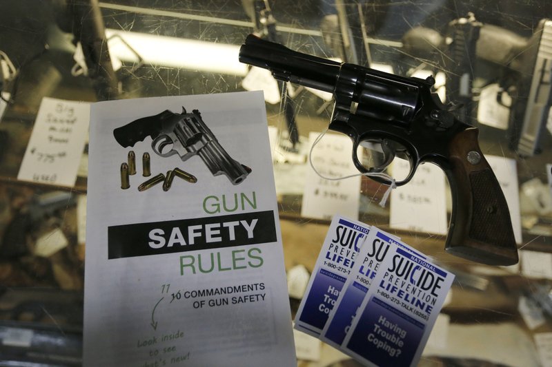File - In this Feb. 23, 2016 file photo, gun safety and suicide prevention brochures are on display next to guns for sale at a local retail gun store in Montrose Colo. The Democrat-controlled Colorado Legislature sent a &quot;red flag&quot; bill Monday, April 1, 2019, to the governor that calls for taking firearms from people who police say pose a threat to themselves or others. Gov. Jared Polis, also a Democrat, has pledged to sign the measure that would place the state among 13 others that have passed such legislation. (AP Photo/Brennan Linsley, File)