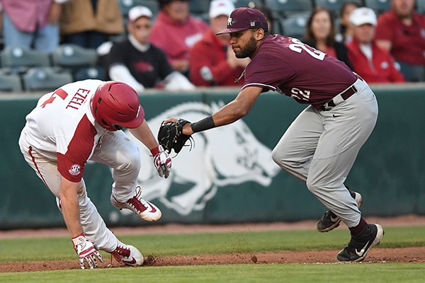 Arkansas' Trevor Ezell is tagged by UALR third baseman Garrett Scott during a game Tuesday, April 2, 2019, in Fayetteville.