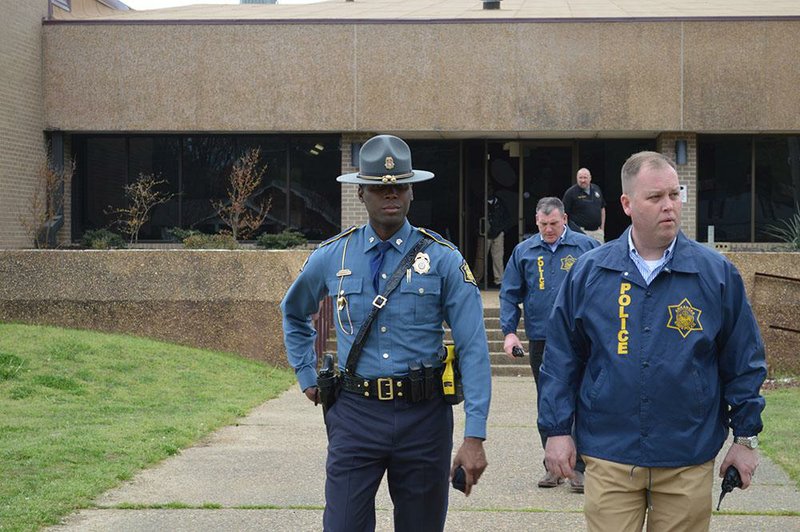 Arkansas State Police investigators collect evidence following a shooting incident at the high school, April 1, 2019. 