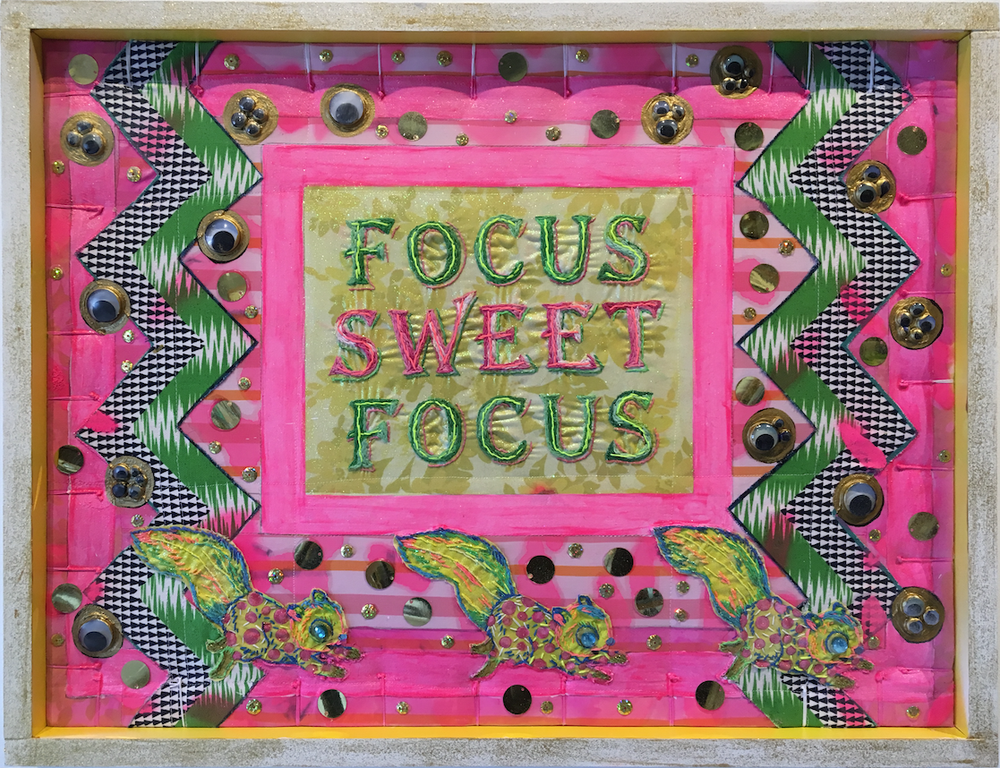 The message is clear on Amanda Linn’s "Post Modern Comfort #1," a work of vintage fabric, embroidery floss, acrylic paint, glitter and miscellaneous craft items. (Courtesy of Gallery 26)