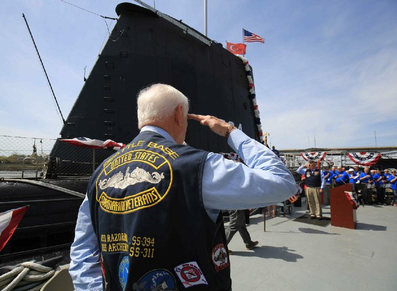 A veteran salutes as the Arkansas Inland Maritime Museum in North Little Rock holds a ceremony Wednesday, April 2, 2019, commemorating the 75th anniversary of the commissioning of the USS Razorback submarine. 