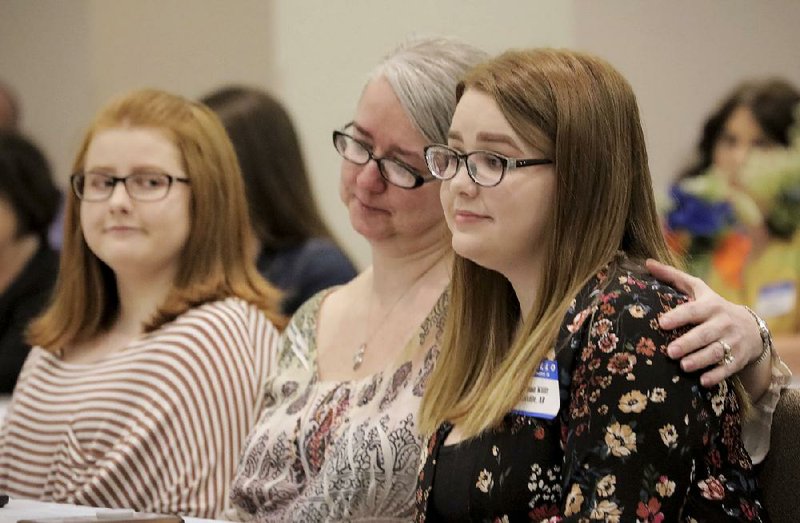 Kidney donor Madison Willis (right) is given a hug by her mother, Melissa Willis (center) as Madison’s sister, Lauren Willis (left), the kidney recipient, looks on during the Chain of Life awards ceremony in Little Rock on Wednesday. Chain of Life honors people who donate a kidney to someone in Arkansas. More photos are available at arkansasonline.com/44kidneyaward/                    