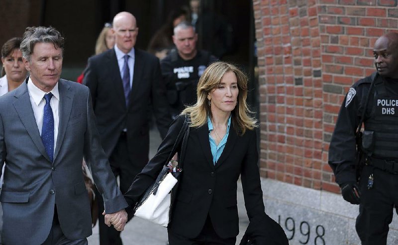 Actress Felicity Huffman departs federal court in Boston with her brother Moore Huffman Jr. (left) on Wednesday, after facing charges in a nationwide college admissions bribery scandal. 