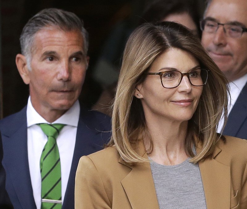 Actress Lori Loughlin, front, and husband, clothing designer Mossimo Giannulli, left, depart federal court in Boston on Wednesday, April 3, 2019, after facing charges in a nationwide college admissions bribery scandal. (AP Photo/Steven Senne)