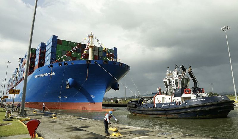 In this December photo, a Panama Canal worker docks the Chinese container ship Cosco at the Panama Canals’ Cocoli Locks, in Panama City. 