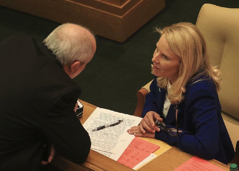 Rep. Mickey Gates talks with Rep. DeAnn Vaught on Thursday during consideration of Vaught’s legislation that would toughen the law on ballot initiatives. The bill “is designed to protect the people of Arkansas’ rights and to ensure citizens’ initiatives are genuinely citizens’ initiatives and not special-interest purchases,” Vaught said. More photos are available at arkansasonline.com/45genassembly/ 