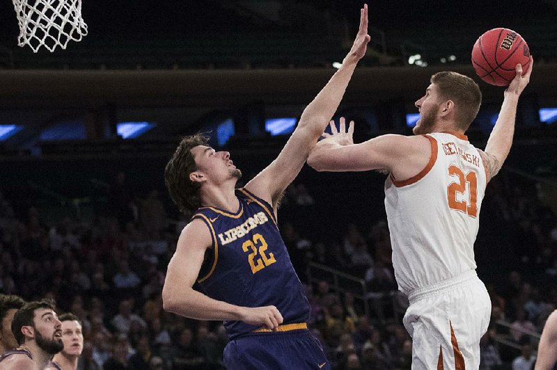 Texas forward Dylan Osetkowski goes to the basket against Lipscomb forward Eli Pepper during the first half of of the men’s NIT championship Thursday at Madison Square Garden in New York. Osetkowski had 19 points and 11 rebounds to lead the Longhorns to an 81-66 victory. 