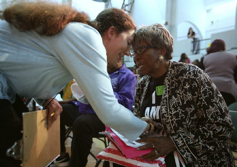 Mariah Reescano (left), drama teacher at Booker Arts Magnet Elementary School in Little Rock, gets a hug from Annie Abrams at an event honoring the life of the Rev. Martin Luther King Jr., who was assassinated April 4, 1968, in Memphis. More photos are available at www.arkansasonline.com/45mlk/ 