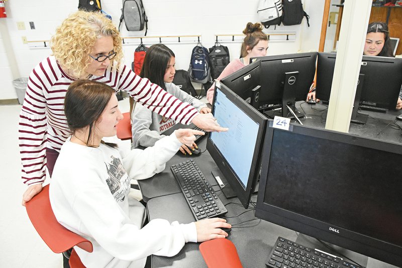 Karma Turner, a computer science teacher at Lake Hamilton Junior High School, helps Ally Ross and other students in the Girls Who Code club. From left, behind Turner, are fellow club members Kaylee Ramey, Riley Hunter and Dianna Webb. Turner was recently named one of the five finalists for the Arkansas Computer Science Educator of the Year by the Arkansas Department of Education.