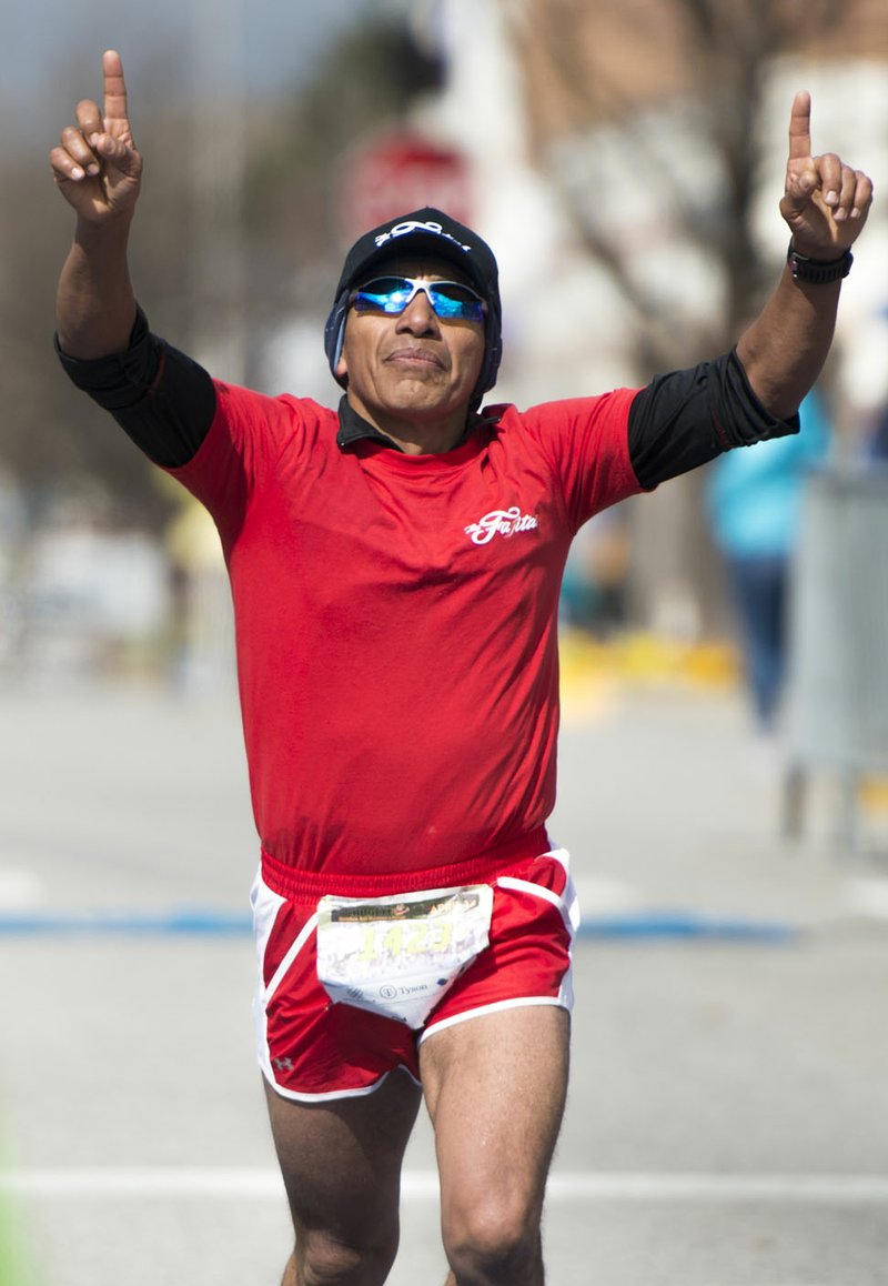 NWA Democrat-Gazette/CHARLIE KAIJO Pompilio Romero of Springdale crosses the finish line during the The 42nd annual Hogeye Marathon last year. A field of more than 2,000 runners are expected to take off today for the 43rd Hogeye Marathon from downtown Springdale.