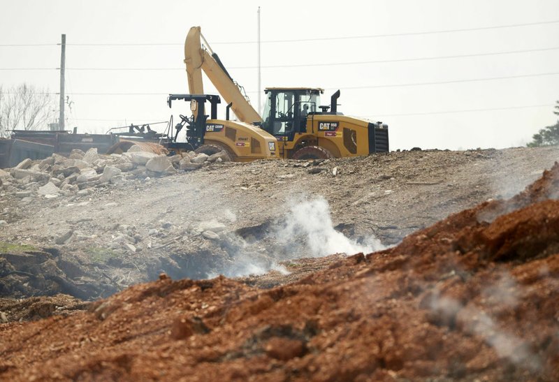 NWA Democrat-Gazette/CHARLIE KAIJO Crew members work Friday at the site of the stump dump in Bella Vista. Access road construction and the other on-site work is projected to take three to four weeks. The road will allow heavy equipment access to the site for excavation and other activities, Davis said.