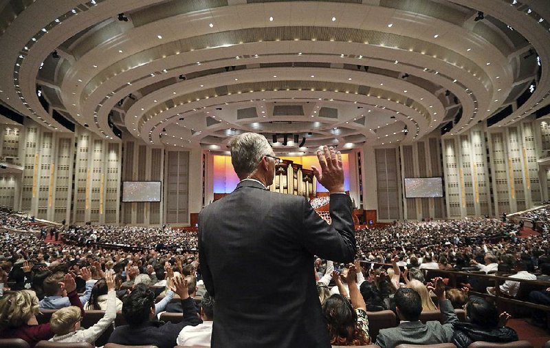 People raise their hands during a vote Saturday at The Church of Jesus Christ of Latter-day Saints’ conference in Salt Lake City. 