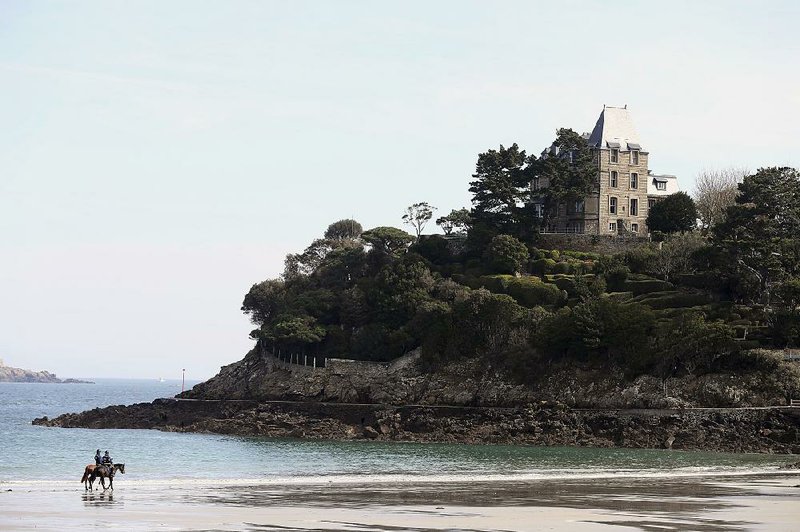 Police officers on horses patrol the beach in Dinard, France, as Group of Seven foreign ministers meet Saturday. 