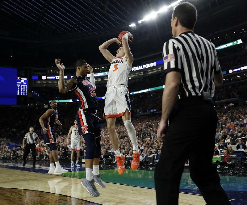 Virginia’s Kyle Guy (5) takes a shot over Auburn’s Samir Doughty in the final second of the Cavaliers’ victory over the Tigers on Saturday in Minneapolis. Doughty was called for a foul on the play. 