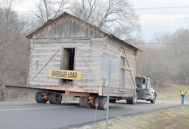 NWA Democrat-Gazette / KEITH BRYANT David Covey, proprietor of D&E House Moving, right, guides his crew into the Bella Vista Historical Museum parking lot with the century-old cabin in tow.