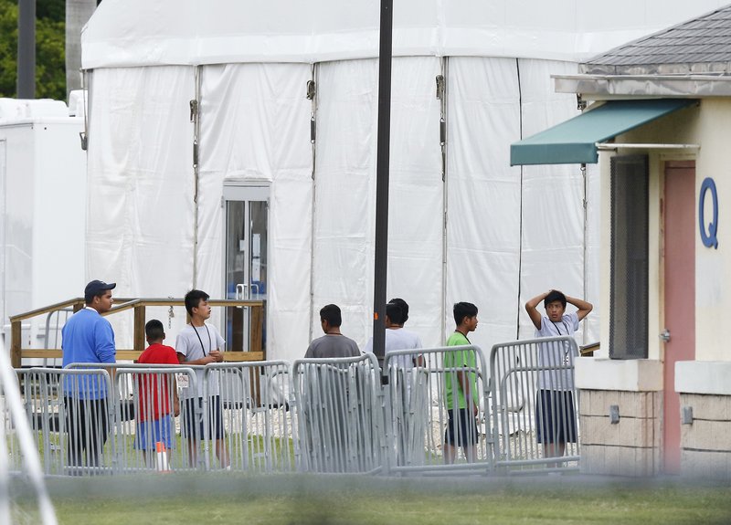 FILE - In this June 20, 2018, file photo, immigrant children walk in a line outside the Homestead Temporary Shelter for Unaccompanied Children, a former Job Corps site that now houses them in Homestead, Fla. The Trump administration wants up to two years to find potentially thousands of children who were separated from their parents at the border before a judge halted the practice last year. The Justice Department said in a court filing late Friday, April 5, 2019 in San Diego that it will take at least a year to review the cases of 47,000 unaccompanied children taken in custody between July 1, 2017 and June 25, 2018. (AP Photo/Brynn Anderson, File)